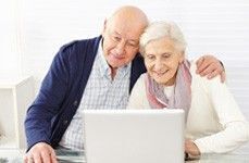 Altes Ehepaar schaut am Laptop das Anbieterverzeichnis.