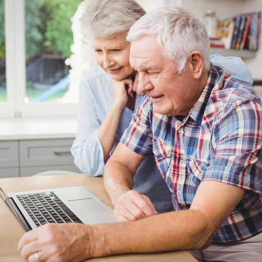 Treppenlift-Ratgeber: Älteres Ehepaar durchstöbert das Internet auf ihrem Laptop nach passenden Anbietern