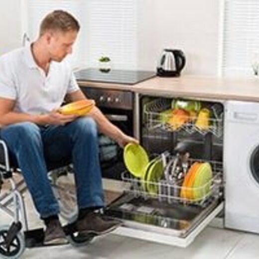 Ein Rollstuhlfahrer in seiner barrierefreien Küche