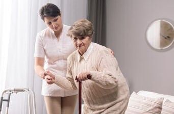 Leben im Alter: Eine Frau hilft einer Seniorin als Stütze