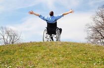 Leben mit Behinderung: Glücklicher Rollstuhlfahrer auf der Wiese