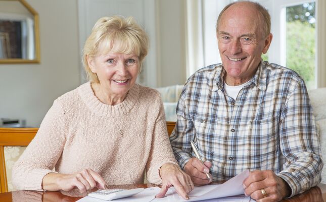 Älteres Ehepaar berechnet die Kosten für einen Treppenlift