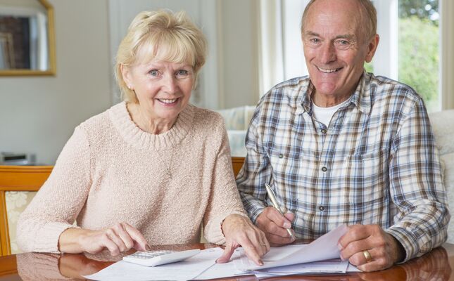 Älteres Ehepaar berechnet die Kosten für einen Treppenlift