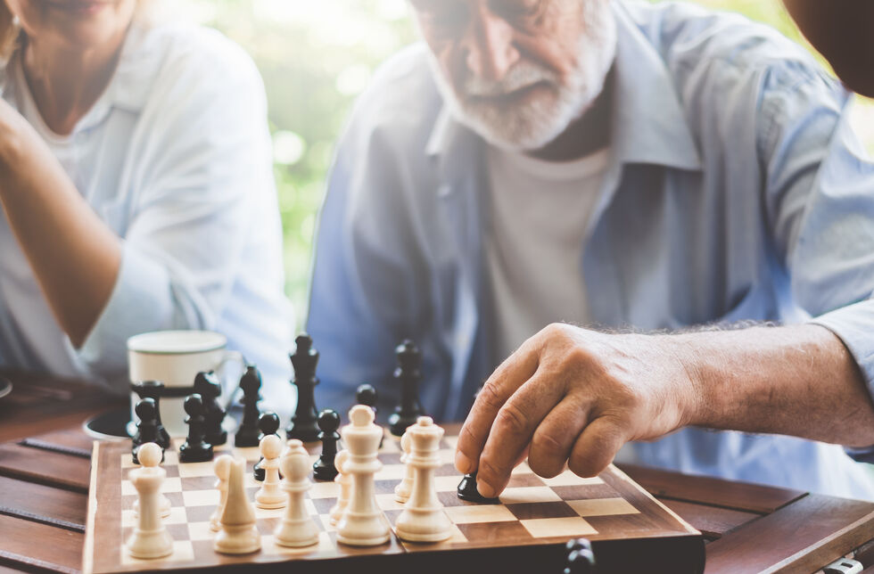 Senior setzt Figur beim Schach spielen