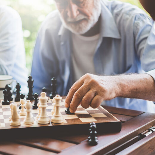 Senior setzt Figur beim Schach spielen