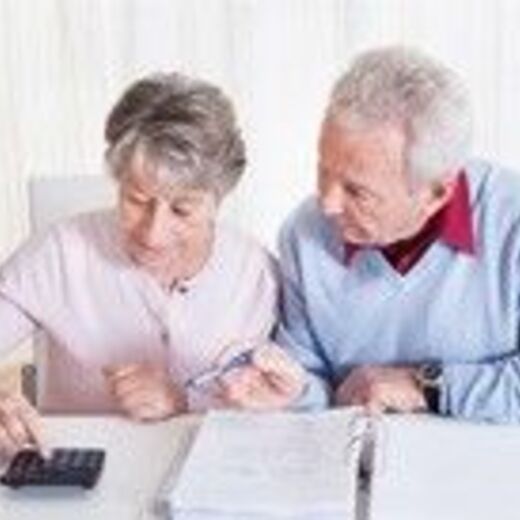 Altes Ehepaar rechnet am Taschenrechner Kosten aus für einen Treppenlift