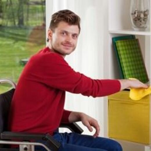 Rollstuhlfahrer reinigt sein Zuhause