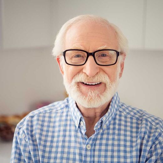 Senior mit Brille lächelt in die Kamera