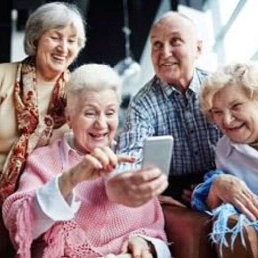 Senioren schauen begeistert auf Smartphone