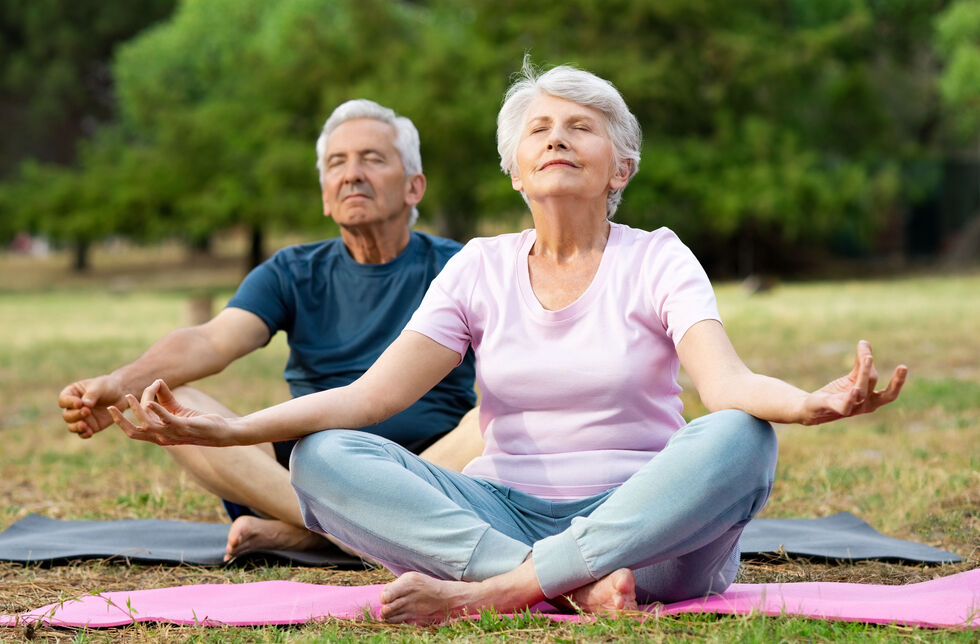 Mann und Frau machen Yoga im Freien