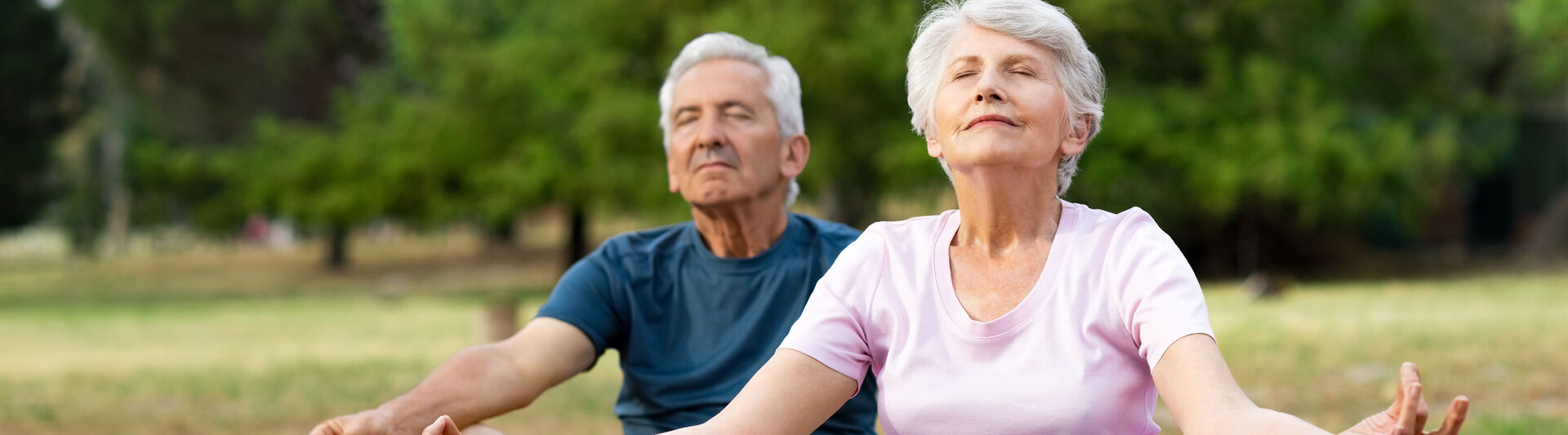 Mann und Frau machen Yoga im Freien