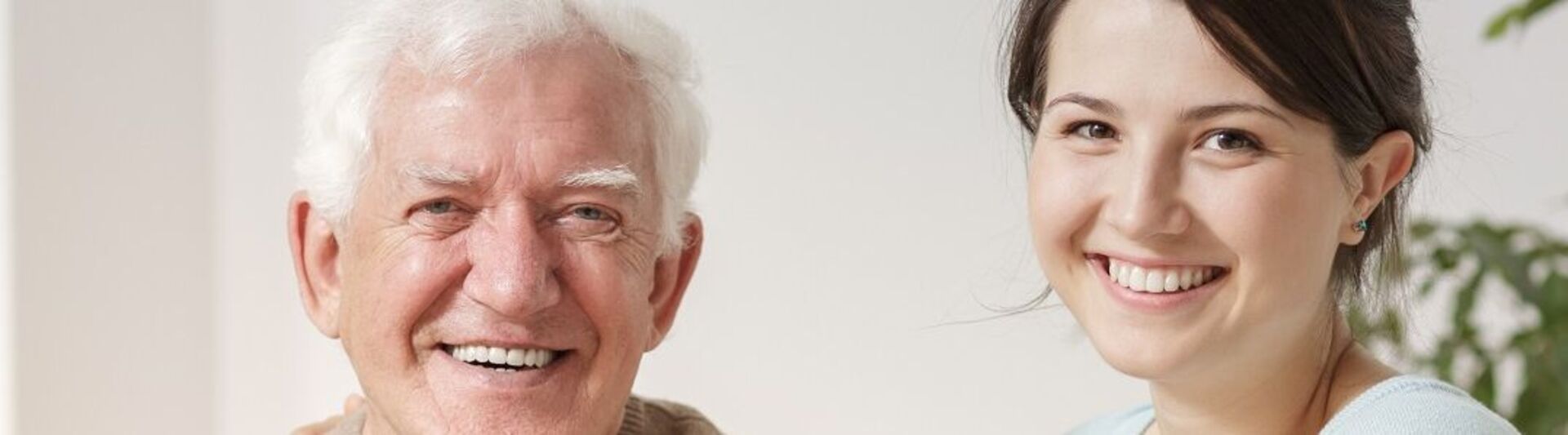 Senior und pflegende Angehörige Junge Frau legt Arm um ihren Vater
