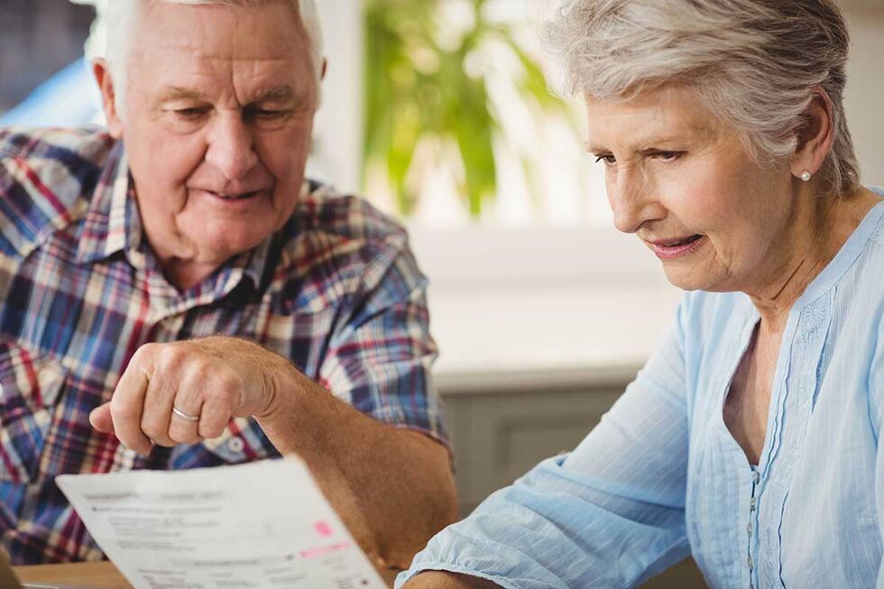Seniorin zeigt ihrem Mann ein Formular der KfW