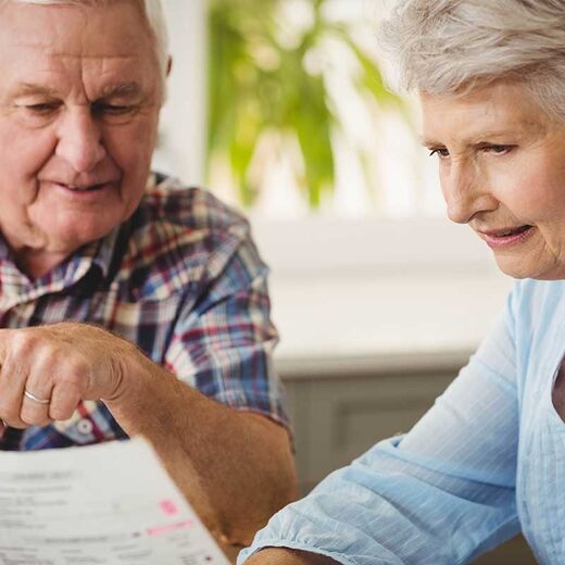Seniorin zeigt ihrem Mann ein Formular der KfW