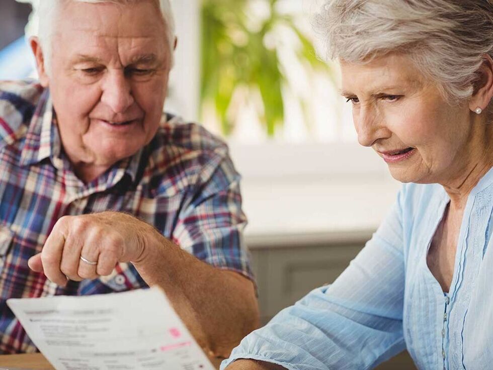 Zuschussformulare von KfW Seniorin zeigt ihrem Mann ein Formular der KfW