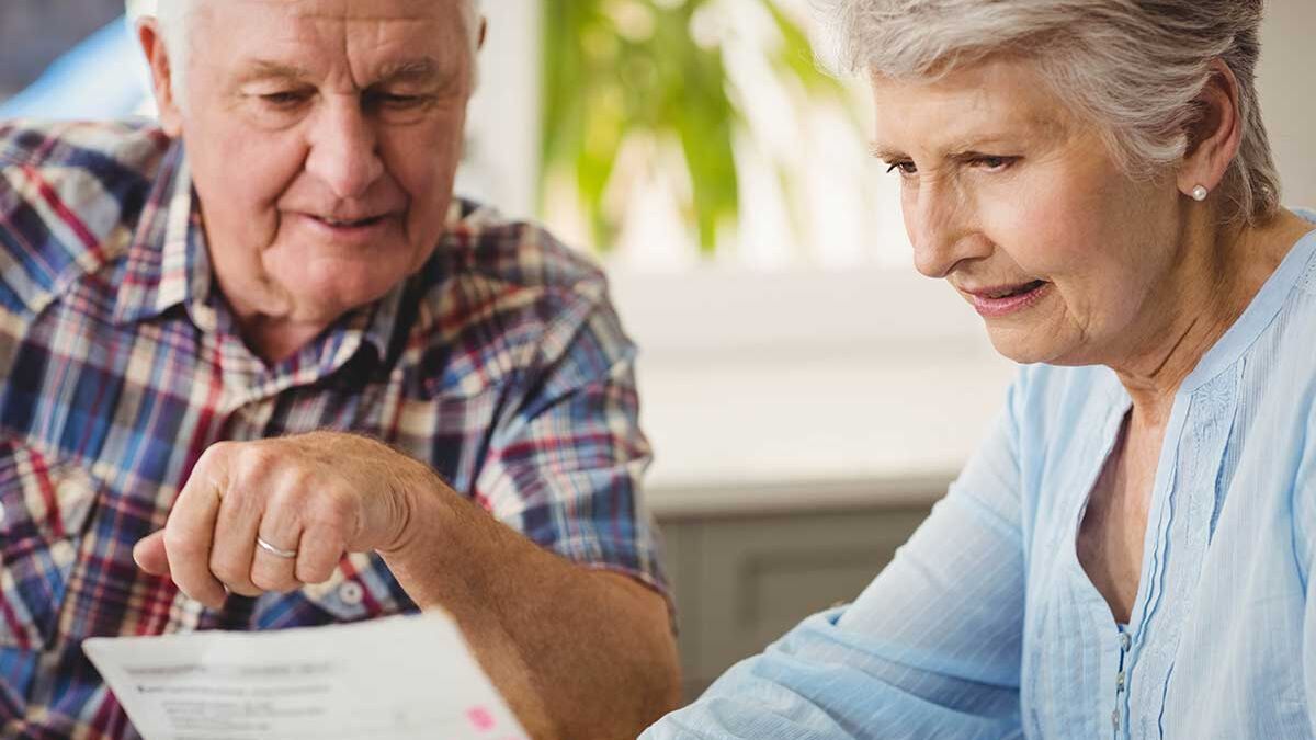 Seniorin zeigt ihrem Mann ein Formular der KfW