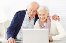 Altes Pärchen sitzt vor dem Laptop und schaut ins Anbieterverzeichnis