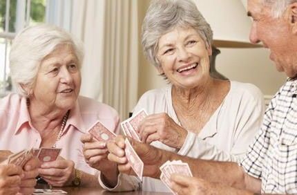 Gruppe von Senioren spielt Karten