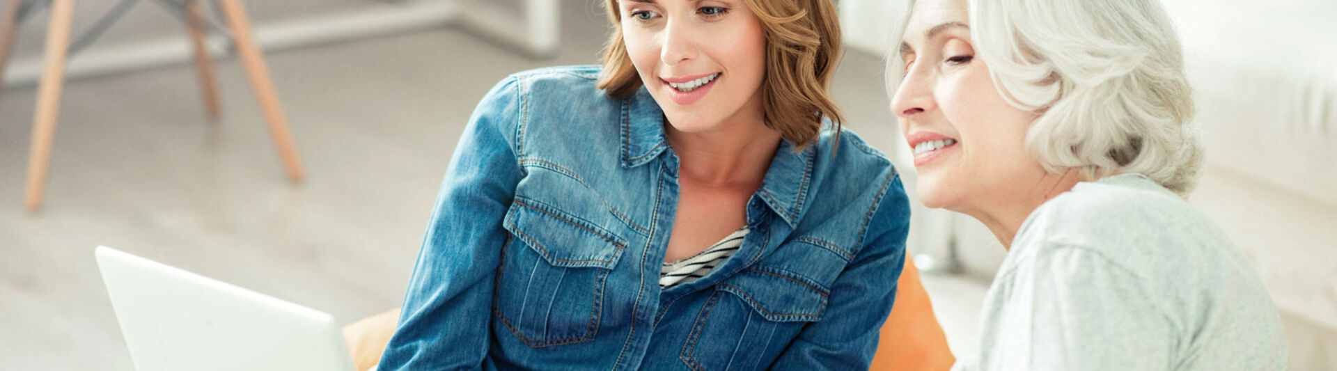 Frau erklärt Seniorin etwas am Laptop