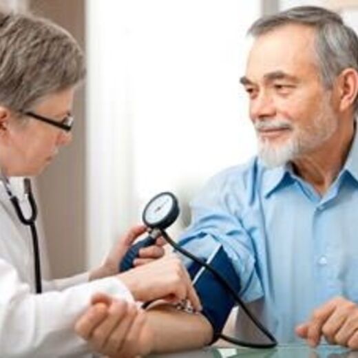 Ärztin untersucht Blutdruck von Senior