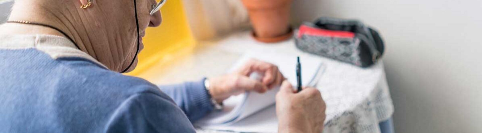 Was Sie über die FINGER-Studie wissen sollten FINGER-Studie: Eine Seniorin mit einer roten Schleife um den Zeigefinger