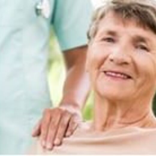 Seniorin schaut lächelnd in die Kamera