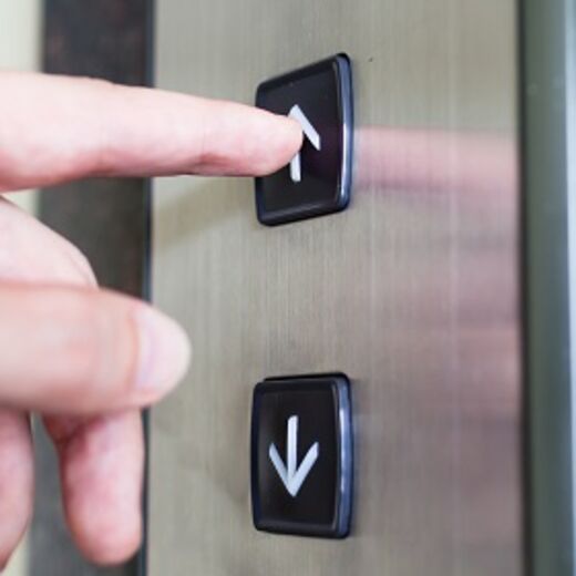 Person drückt einen Knopf um den Senkrechtlift zu rufen