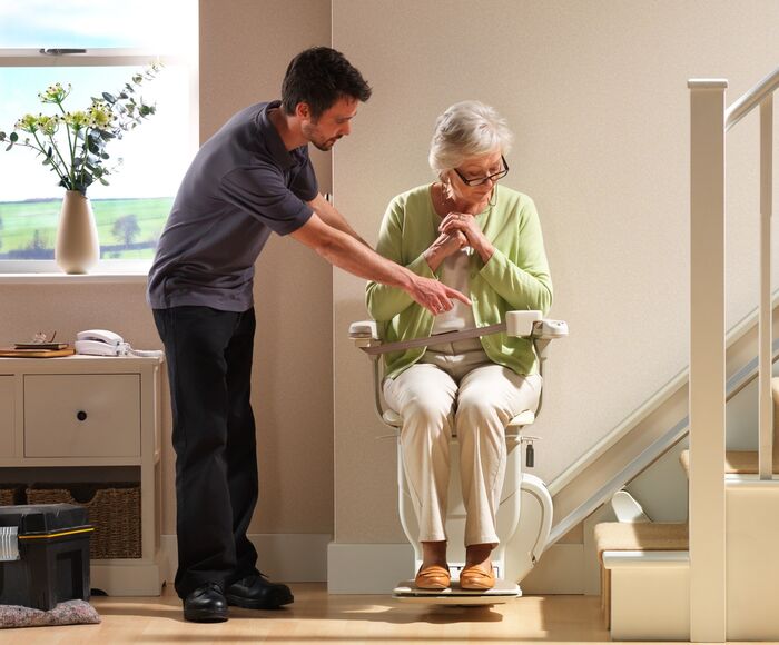 Frau fährt auf einem Treppenlift zur Probe