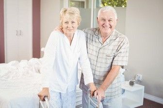 Seniorenpaar steht glücklich im geräumigen Schlafzimmer