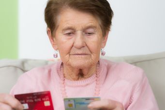 Seniorin mit Versichertenkarte der Krankenkasse