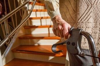 Wohnen im Alter: Mann mit Rollator vor einer Treppe