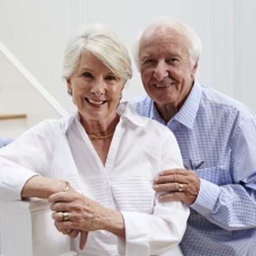 Ein älteres Ehepaar steht im Treppenhaus
