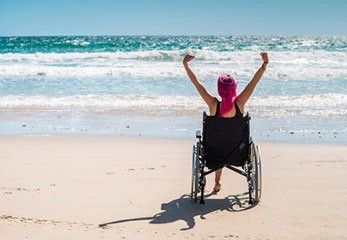 Rollstuhlfahrerin beim barrierefreien Strandurlaub Urlaub mit Rollstuhl am Strand