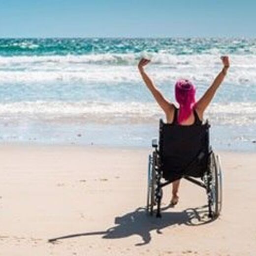 Frau im Rollstuhl am Strand