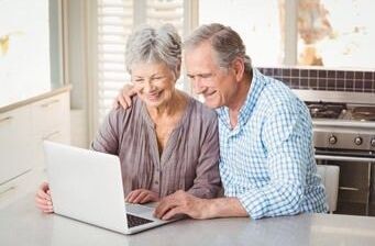 Leben im Alter: Ein Seniorenpaar sitzt vor einem Laptop