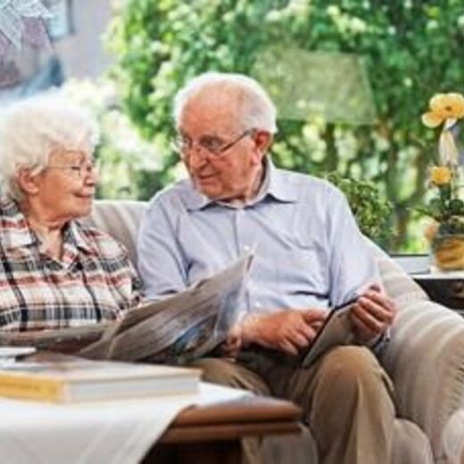 Seniorenpaar sitzt im barrierefreien Wohnzimmer am Couchtisch