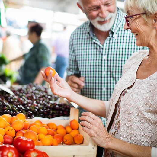 Seniorenpaar kauft Obst auf dem Markt