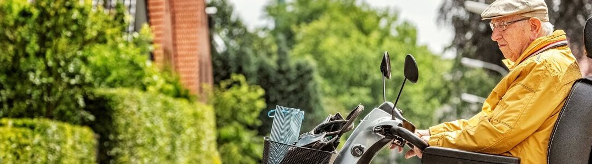 Senior auf Elektromobil Mann fährt mit Elektromobil auf die Straße