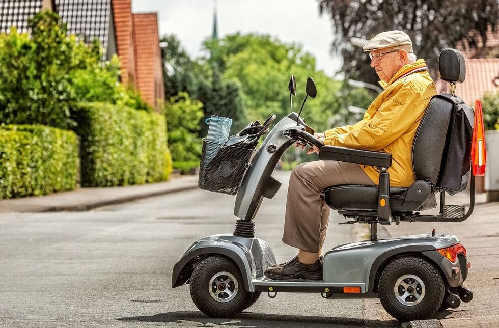 Mann fährt mit Elektromobil auf die Straße