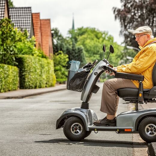 Mann fährt mit Elektromobil auf die Straße