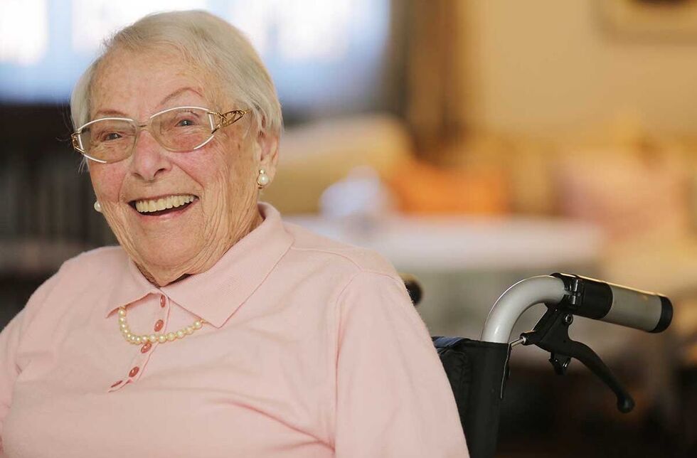 Zuschüsse für Menschen mit Behinderung: Foto einer Seniorin im Rollstuhl, die sich der Kamera zuwendet