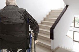 Wohnen im Alter: Ein Rollstuhlfahrer vor einer Treppe