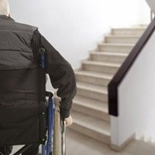Wohnen im Alter: Ein Rollstuhlfahrer vor einer Treppe
