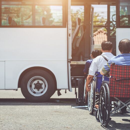 Barrierefrei Reisen: Eine Reisegruppe in Rollstühlen vor einem Bus