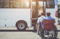 Barrierefrei Reisen: Eine Reisegruppe in Rollstühlen vor einem Bus