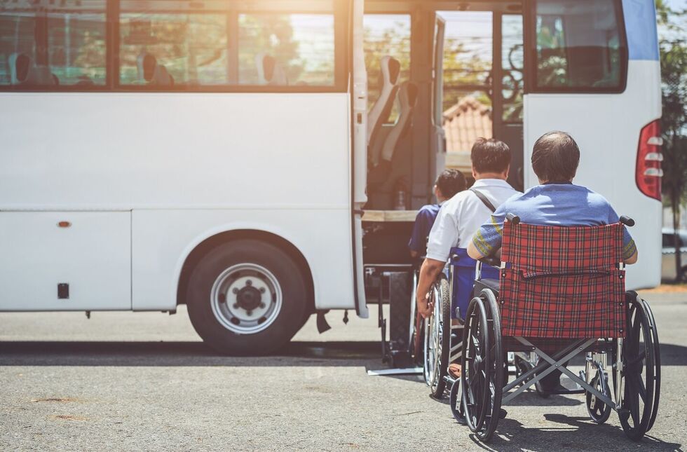 Barrierefrei Reisen: Eine Reisegruppe in Rollstühlen vor einem Bus