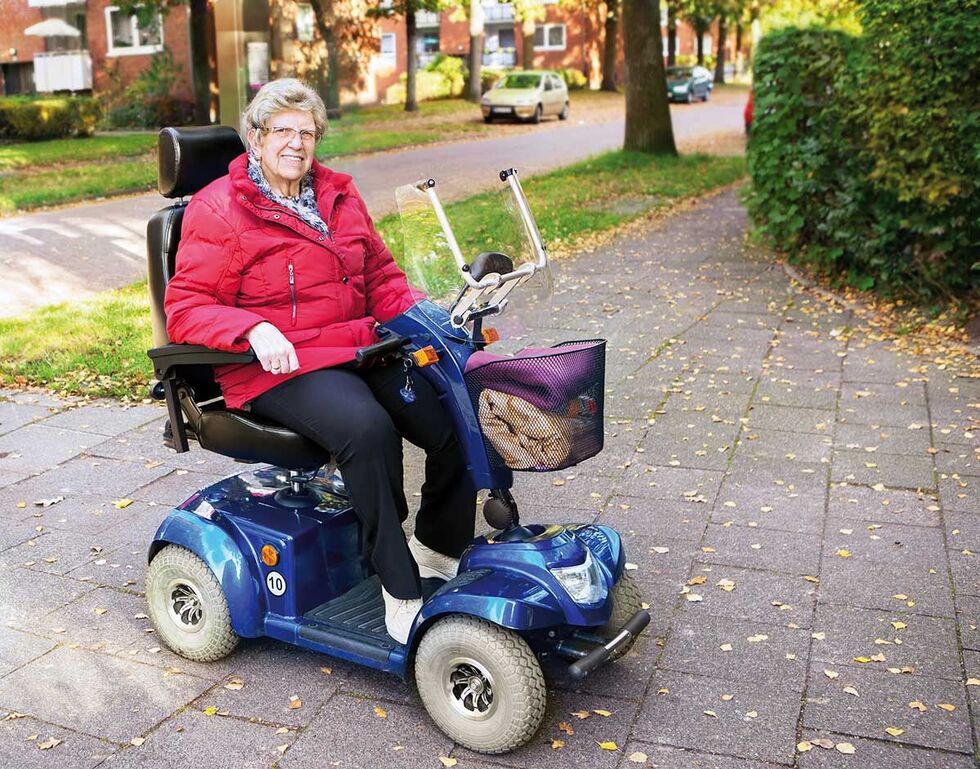Seniorin auf Elektromobil Seniorin auf Elektromobil