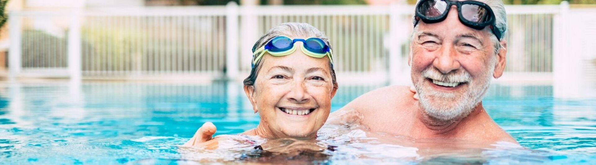 Seniorenschwimmen draußen Senioren mit Schwimmbrillen schwimmen