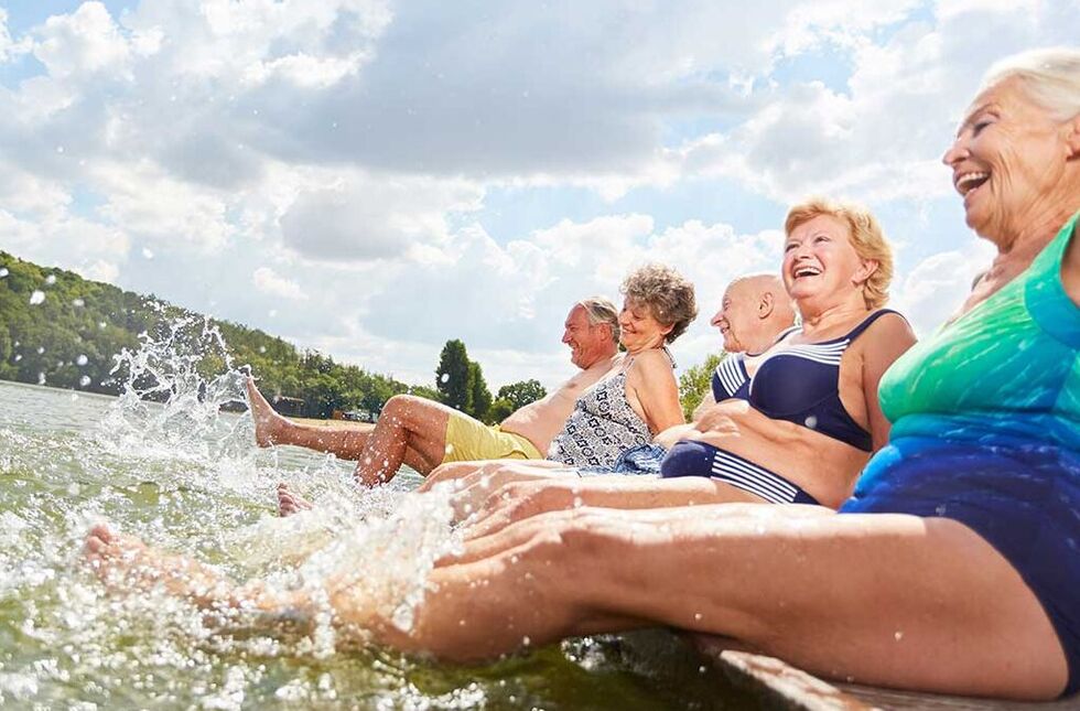 Wohnen im Alter: Senioren-Wohngemeinschaft sitzt zusammen auf einer Parkbank