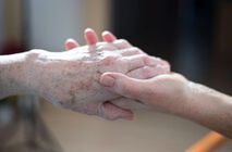 Ambulante Pflege reicht die Hand Eine ältere Person und eine junge Person geben sich die Hand